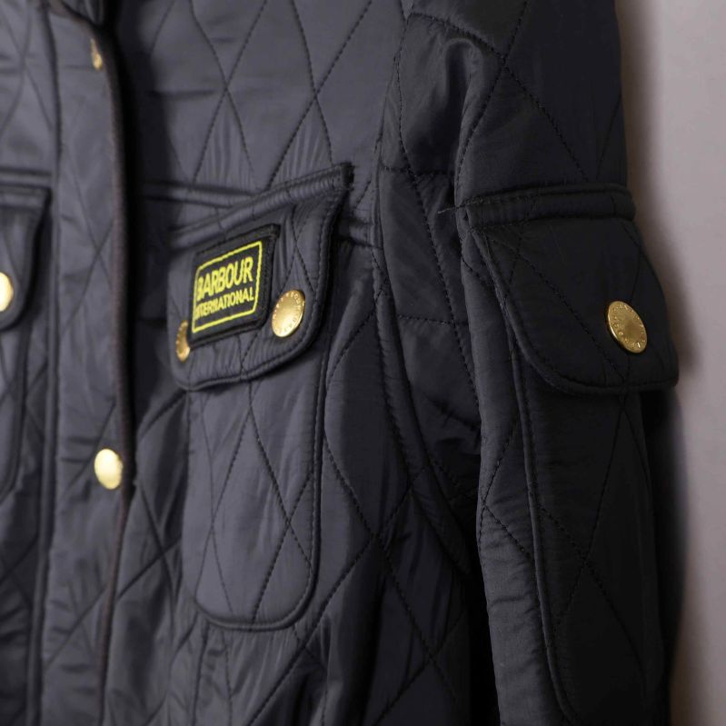 Ärm och axel med ficka och knapp på quiltad jacka