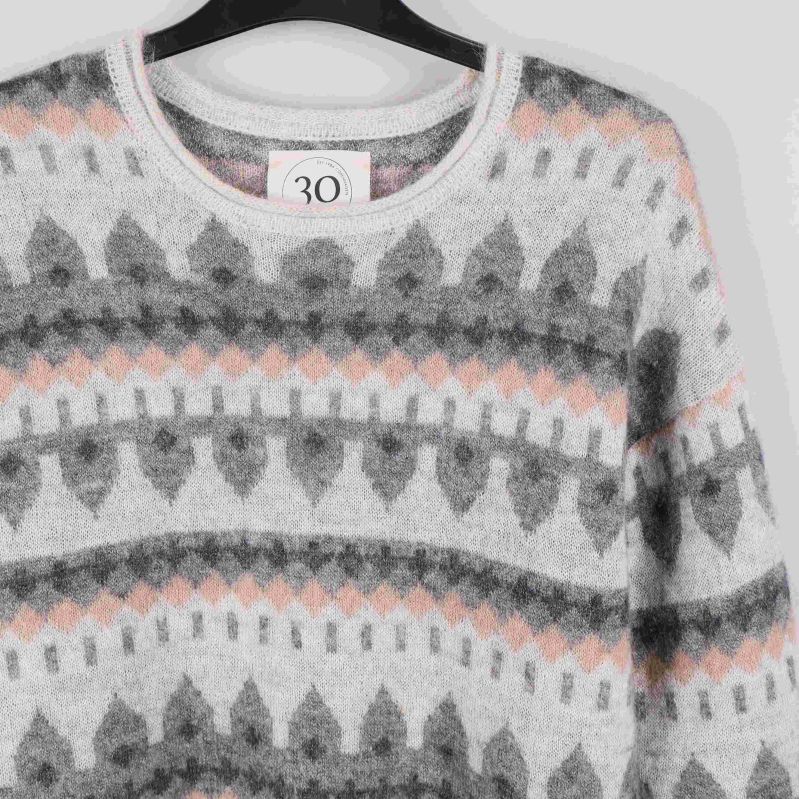 Övre del av stickad tröja med rund hals och mönster