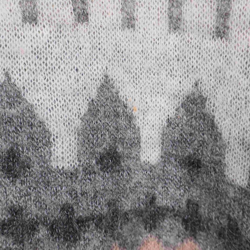 Närbild på garn och mönster i grå och rosa nyanser