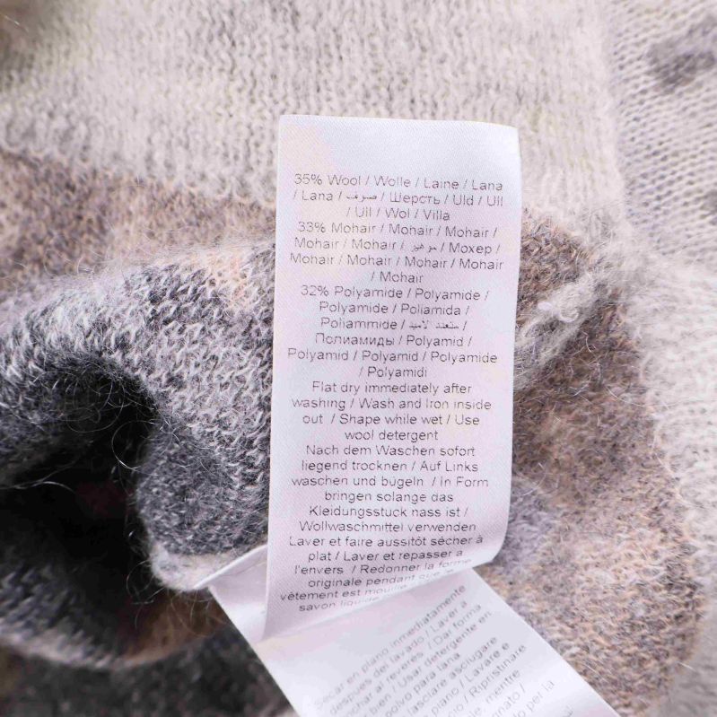 Materiallapp med text om olika fibrer i plagget