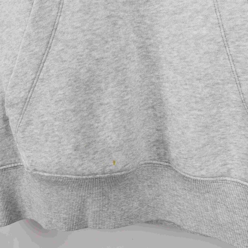 Närbild av känguruficka och nederkant på ljusgrå hoodie