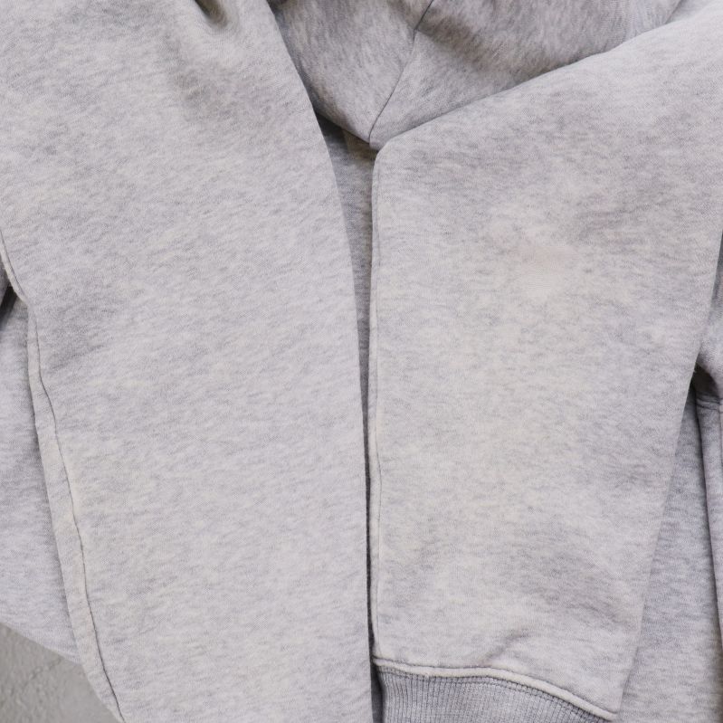 Närbild av ärmar på ljusgrå hoodie, lätt slitna
