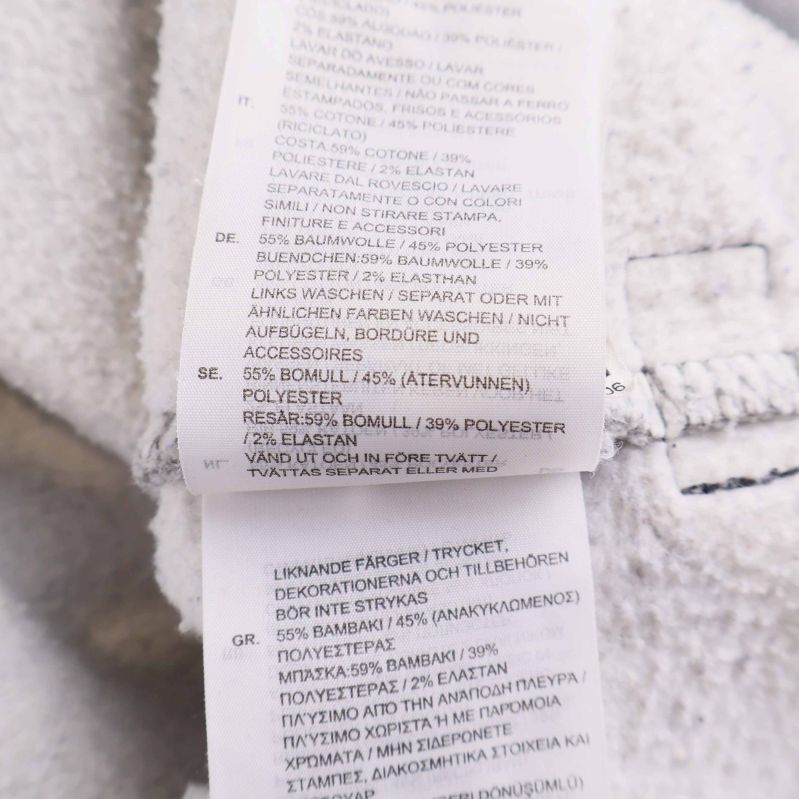 Materiallapp som visar innehåll: 55% bomull, 45% polyester