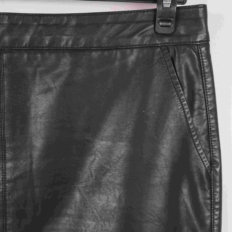 Närbild på ficka och söm på svart konstläderkjol