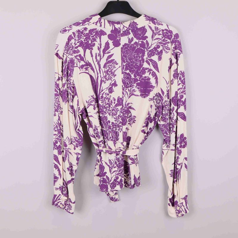 Baksidan av blommig omlottblus med lila mönster