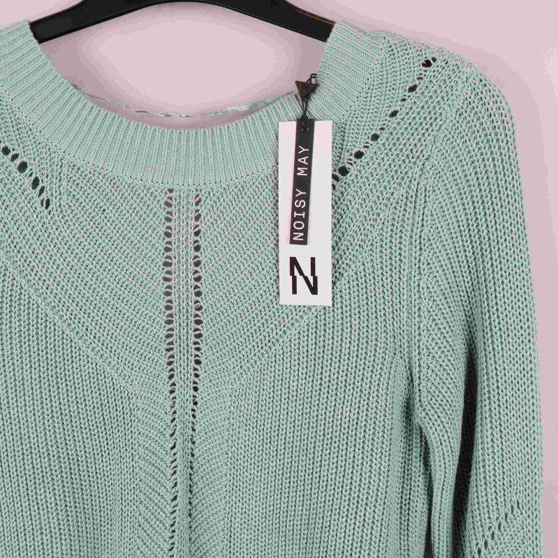 Närbild på hålmönster och halsringning på tröjan