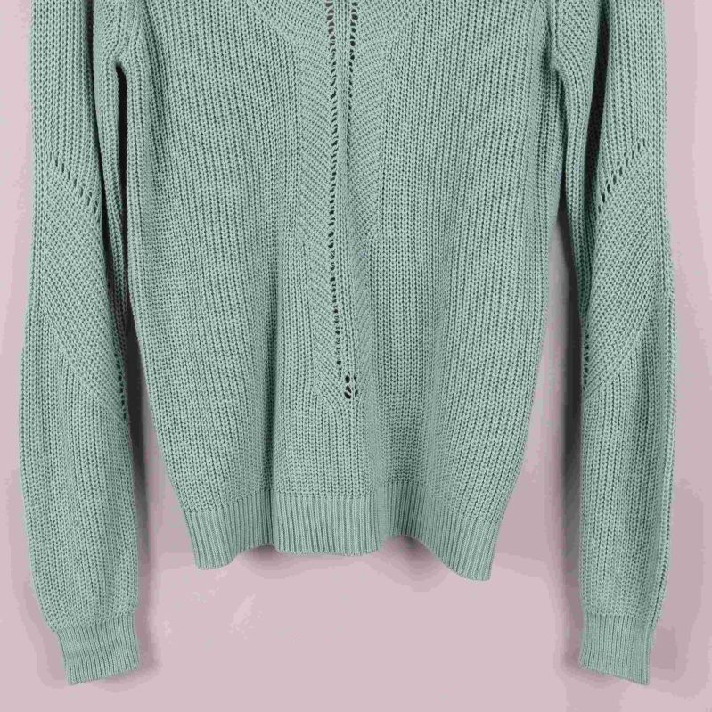 Närbild på tröjans nedre framdel och ärmslut