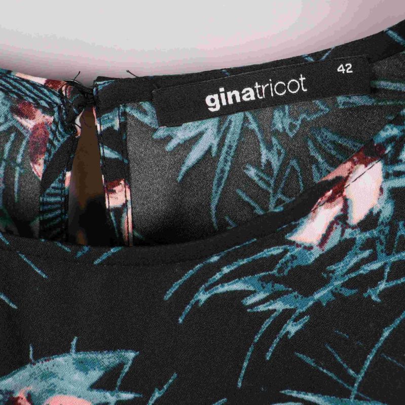 Närbild på Gina Tricot-etikett och storleksmärkning 42 i halsen