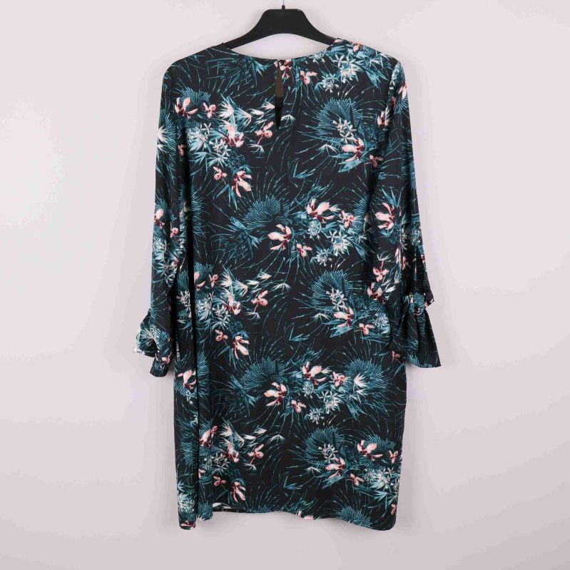 Baksidan av mönstrad klänning med knapp vid nacken