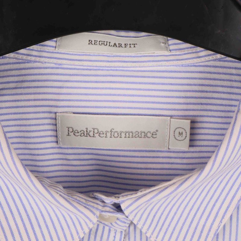 Närbild på Peak Performance-märke och etikett i skjortan