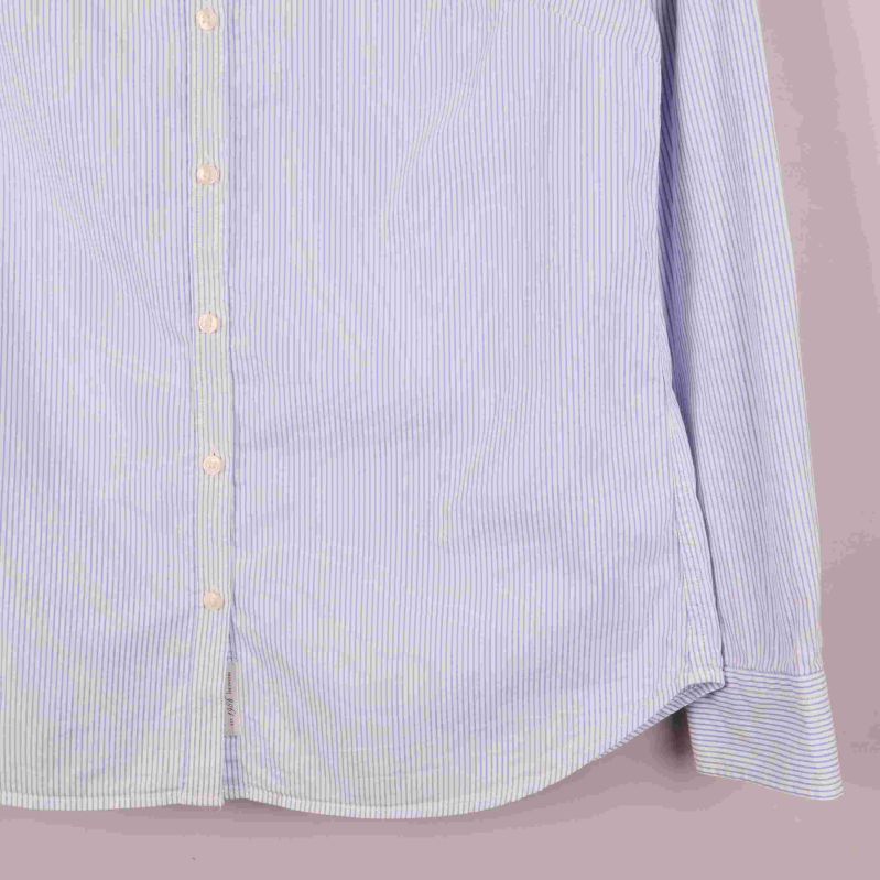 Närbild på skjortans nederdel och knappslå på vänster sida