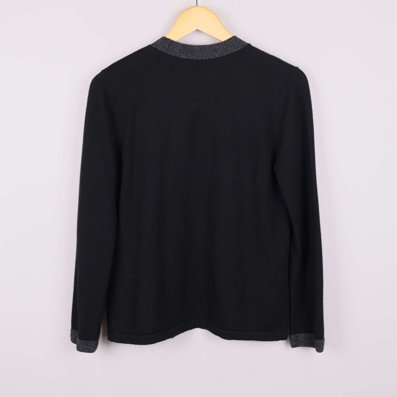 Baksidan av svart kofta med grå kantband