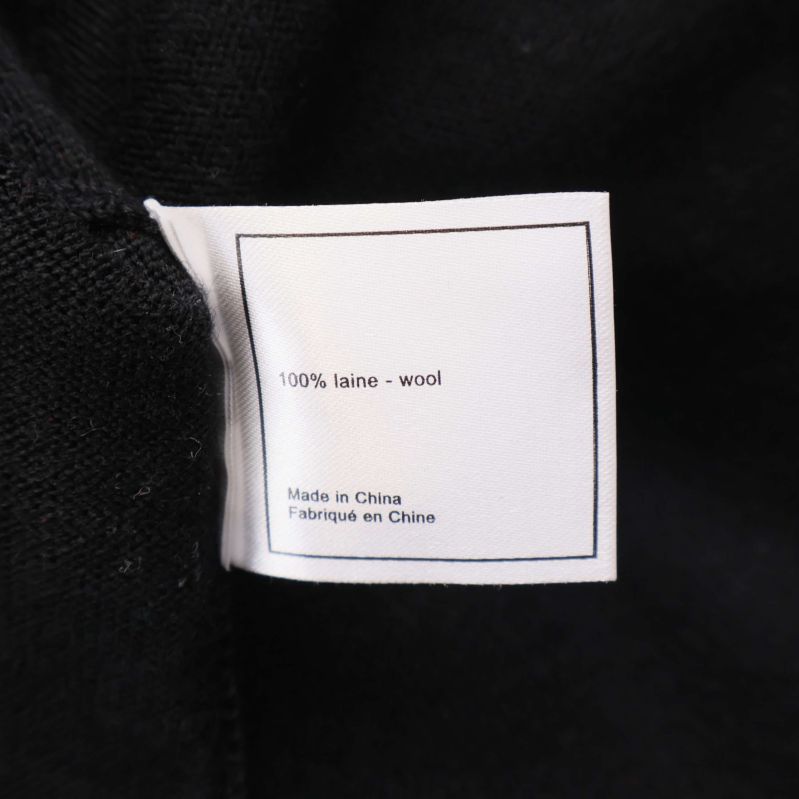 Materialetikett med 100% ull på vit bakgrund