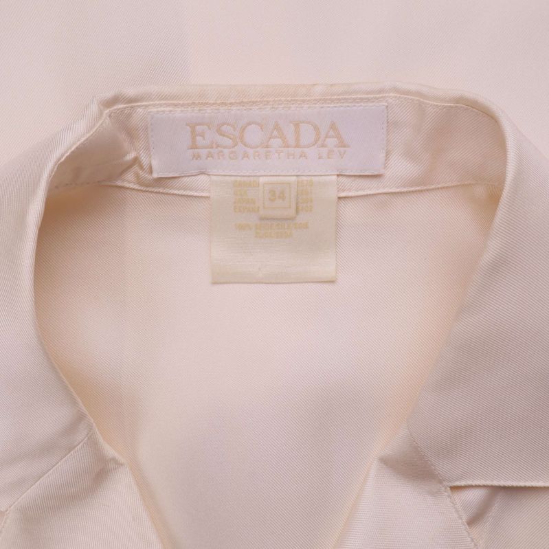 Närbild på etikett med Escada-logotyp och storleksmärkning