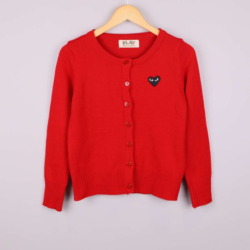 Klar röd kofta på galge med svart hjärtapplikation