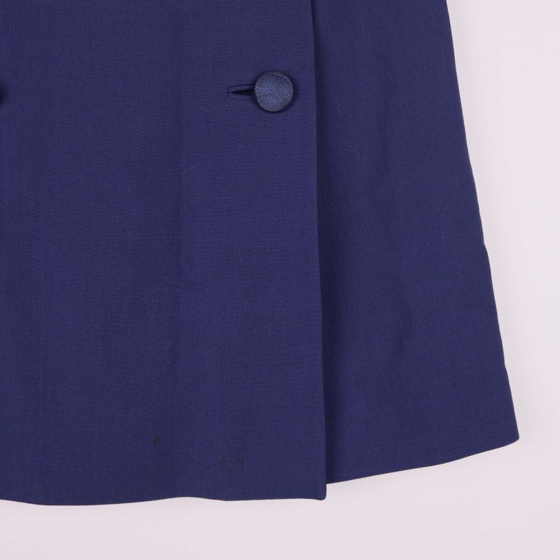 Närbild nertill på mörkblå kjol med knappdetalj