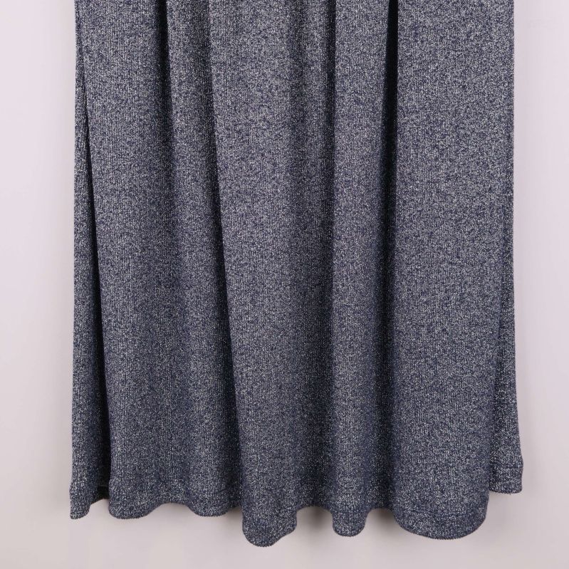 Närbild på nederkanten av grå veckad kjol