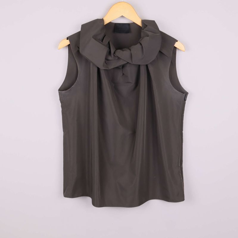 Framsidan av brun ärmlös topp med draperad krage
