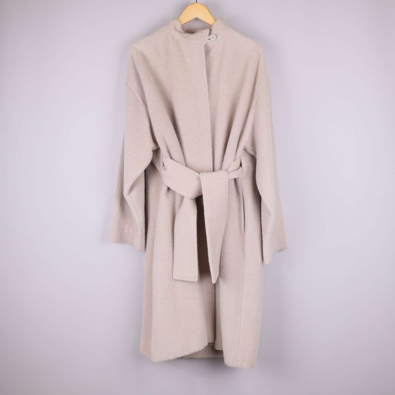 Ljusbeige kappa med bälte hängande 