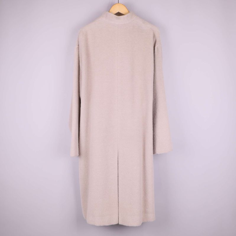 Baksidan av ljusbeige kappa 