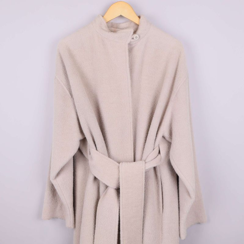 Framifrån på ljusbeige kappa med knäppt krage