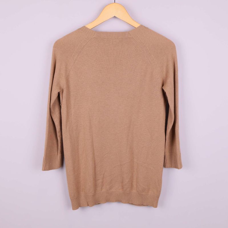 Baksida av beige stickad tröja 