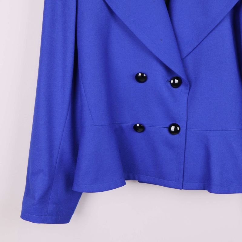 Detaljbild på kavajens vänstra ärm och knapp