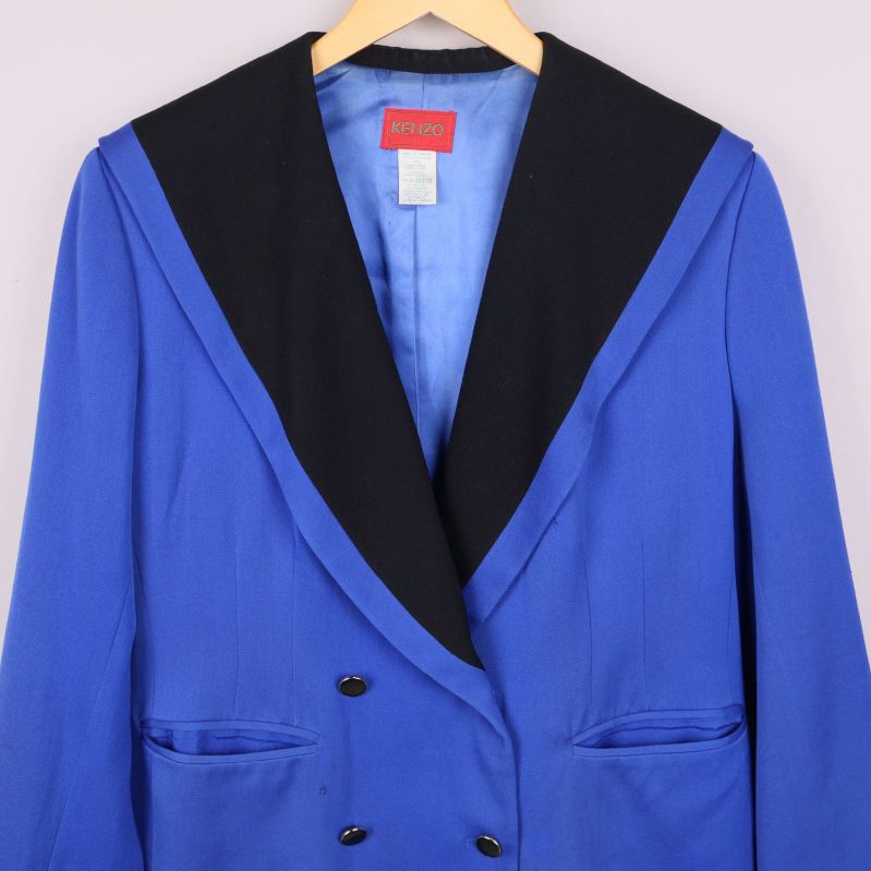 Framsida med dubbelknäppning och bred kontrastkrage