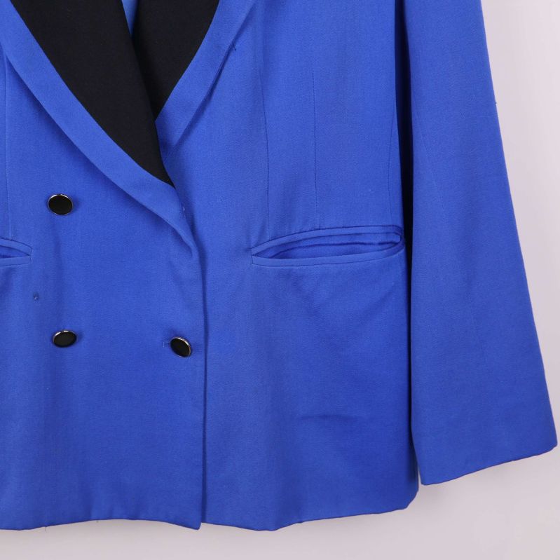 Närbild av höger ficka och blått tyg, litet hål i bild