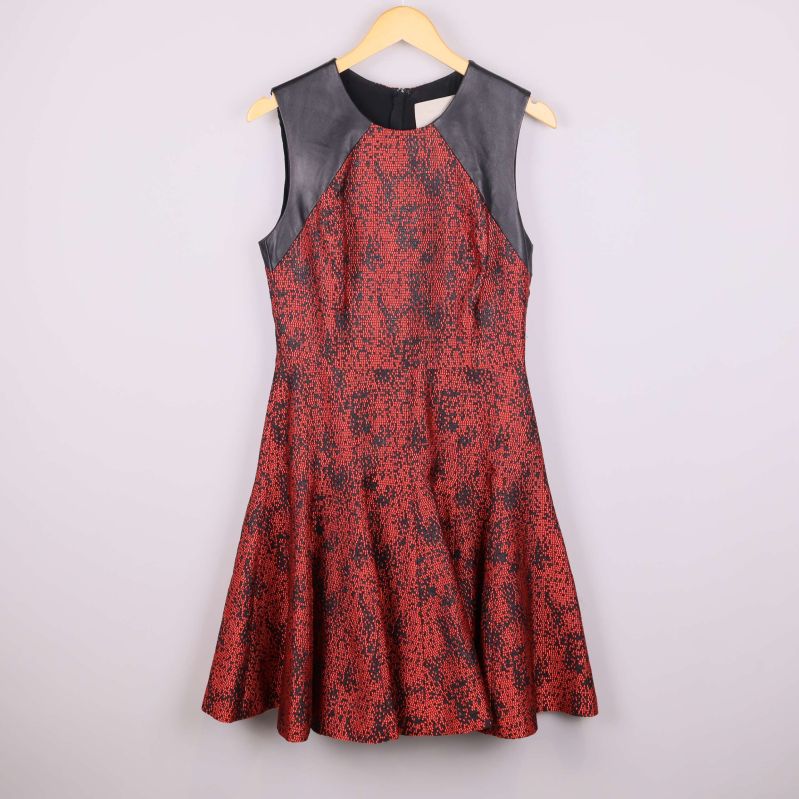 Ärmlös klänning med skinn detaljer på axlar och rött mönster, framifrån