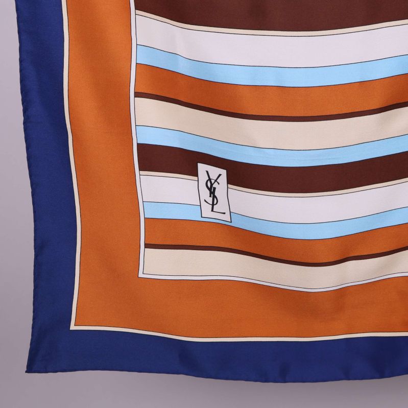 Närbild på scarfens hörn och YSL-logga