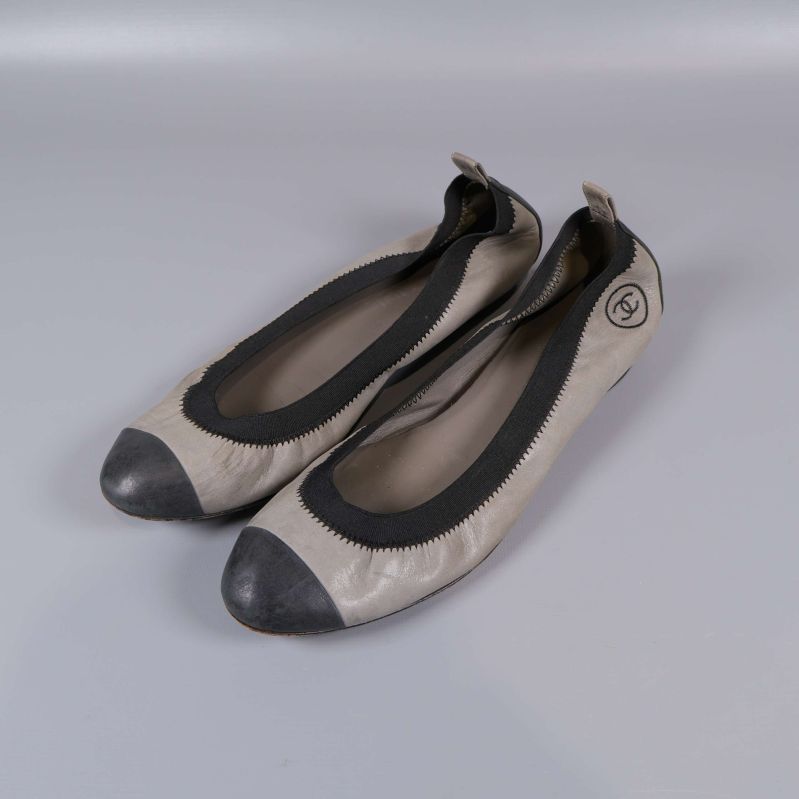 Ballerinaskor i grått med svarta detaljer från sidan