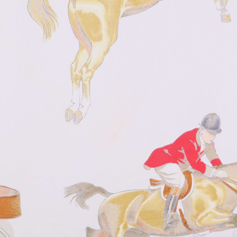 Närbild på ryttare i röd jacka på häst