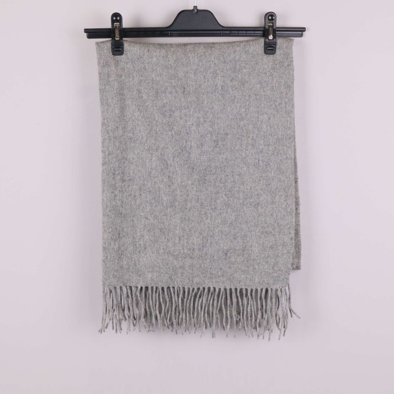 Grå sjal med fransar hängande på galge