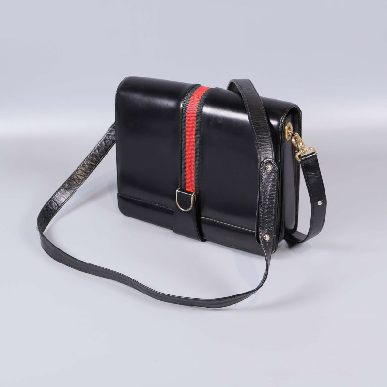 Svart axelremsväska med röd och grön rand på framsidan