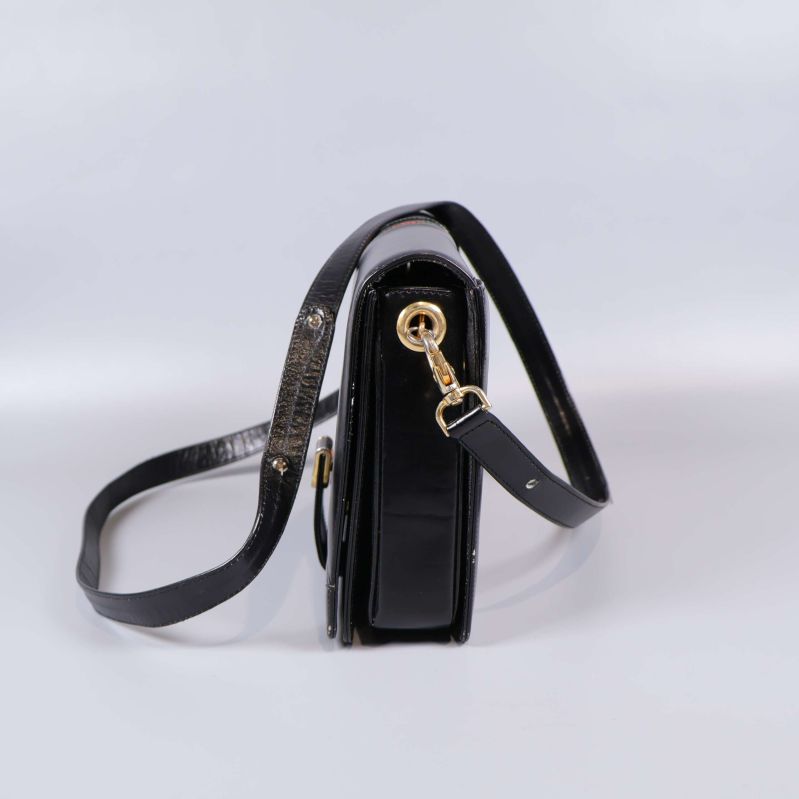 Sidovy av svart axelremsväska med justerbar rem