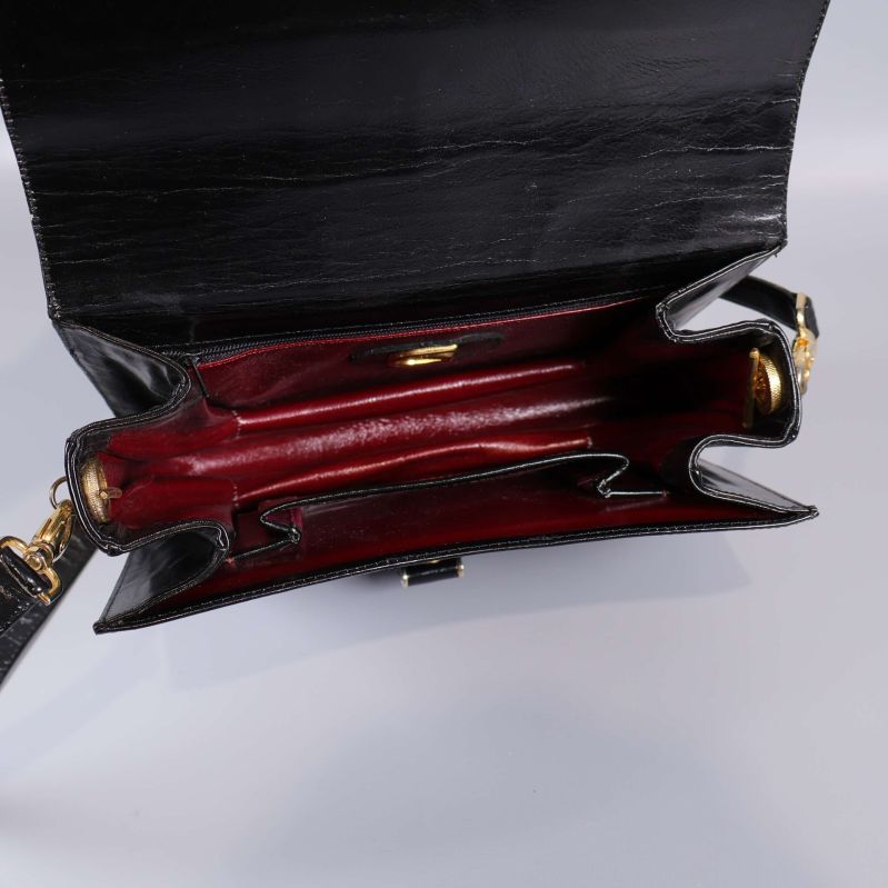 Väskan  öppen visar vinröd insida och många fack