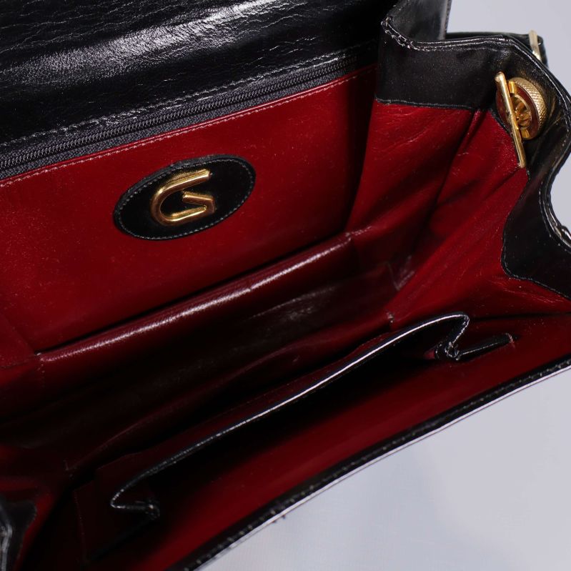 Närbild på vinrött foder och innerfack med G-detalj