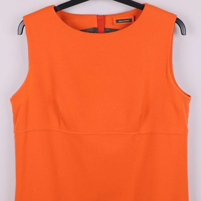 Närbild på överdelen av orange ärmlös klänning