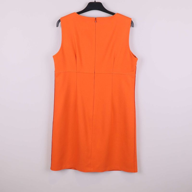 Baksida av orange ärmlös klänning hängande på galge
