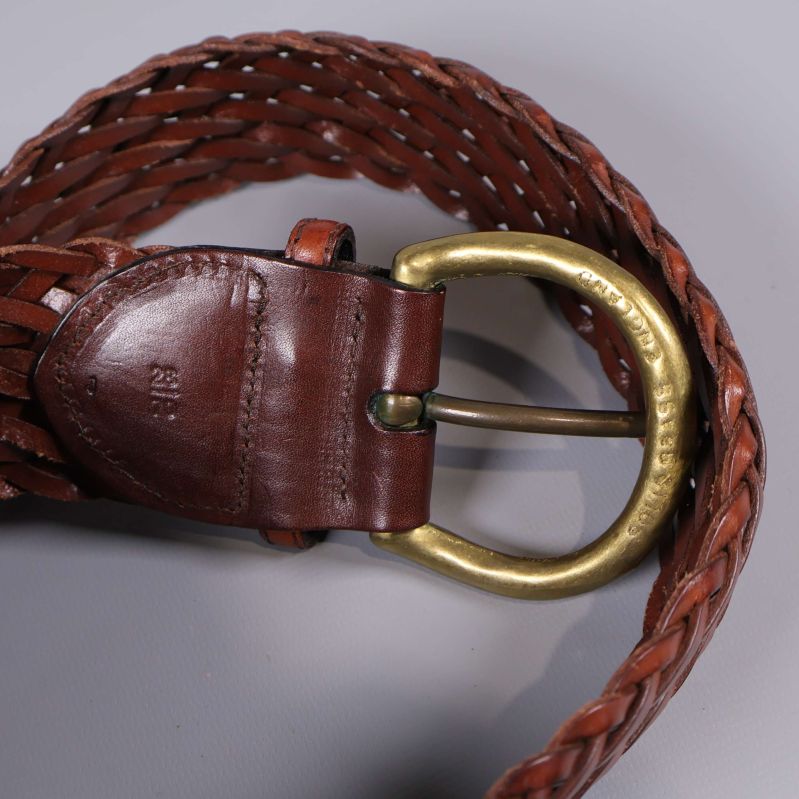 Närbild på bälteslås och präglad logga