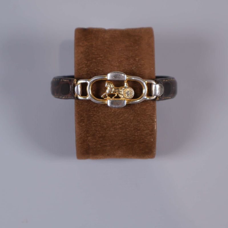 Armband med mörkbrunt band och guldfärgat spänne