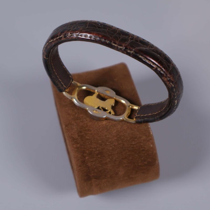 Armband på brun kudde med guldfärgade detaljer