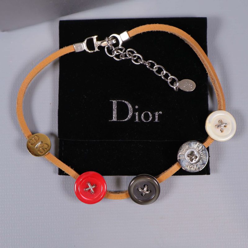 Närbild på halsband med knappar från Dior