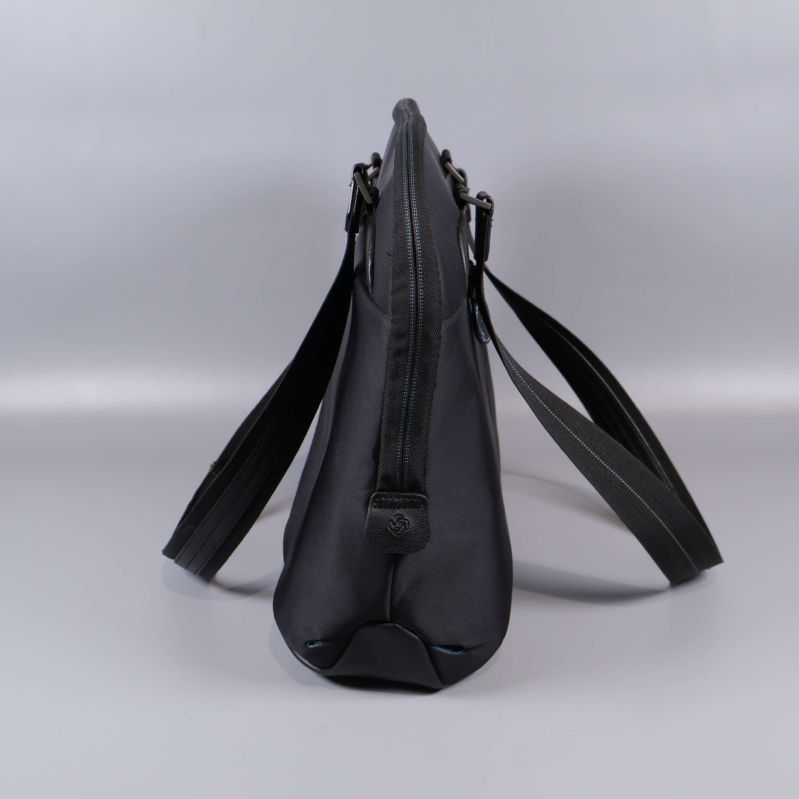 Smal profilvy på svart datorväska i tyg och läder