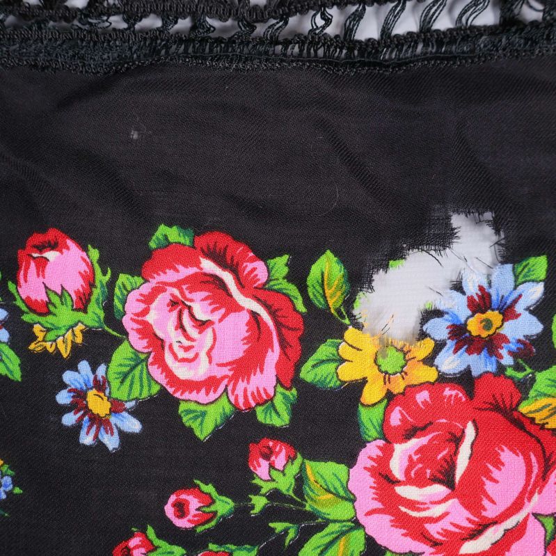 Närbild av blommig sjal med synlig slitage