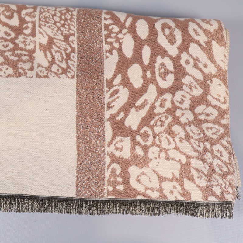 Närbild på mönstrad beige och brun halsduk