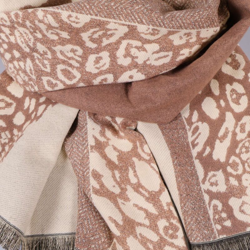 Närbild på halsdukens mönster och franskant i beige och brunt