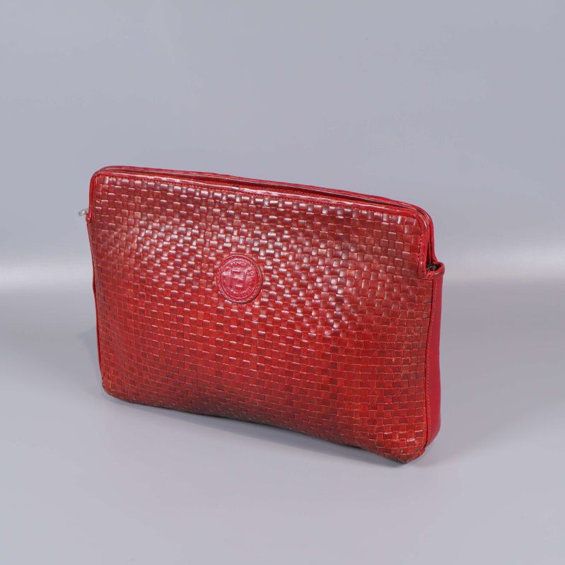Framsidan av röd flätad läderväska