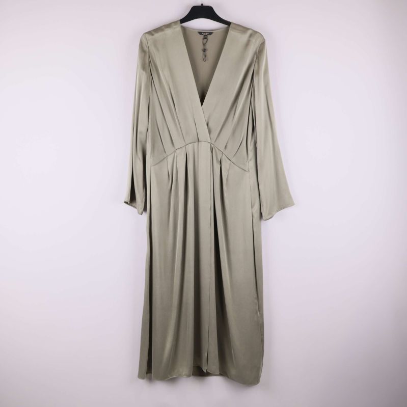 Lång ljusgrön klänning hängandes på galge med V-ringning